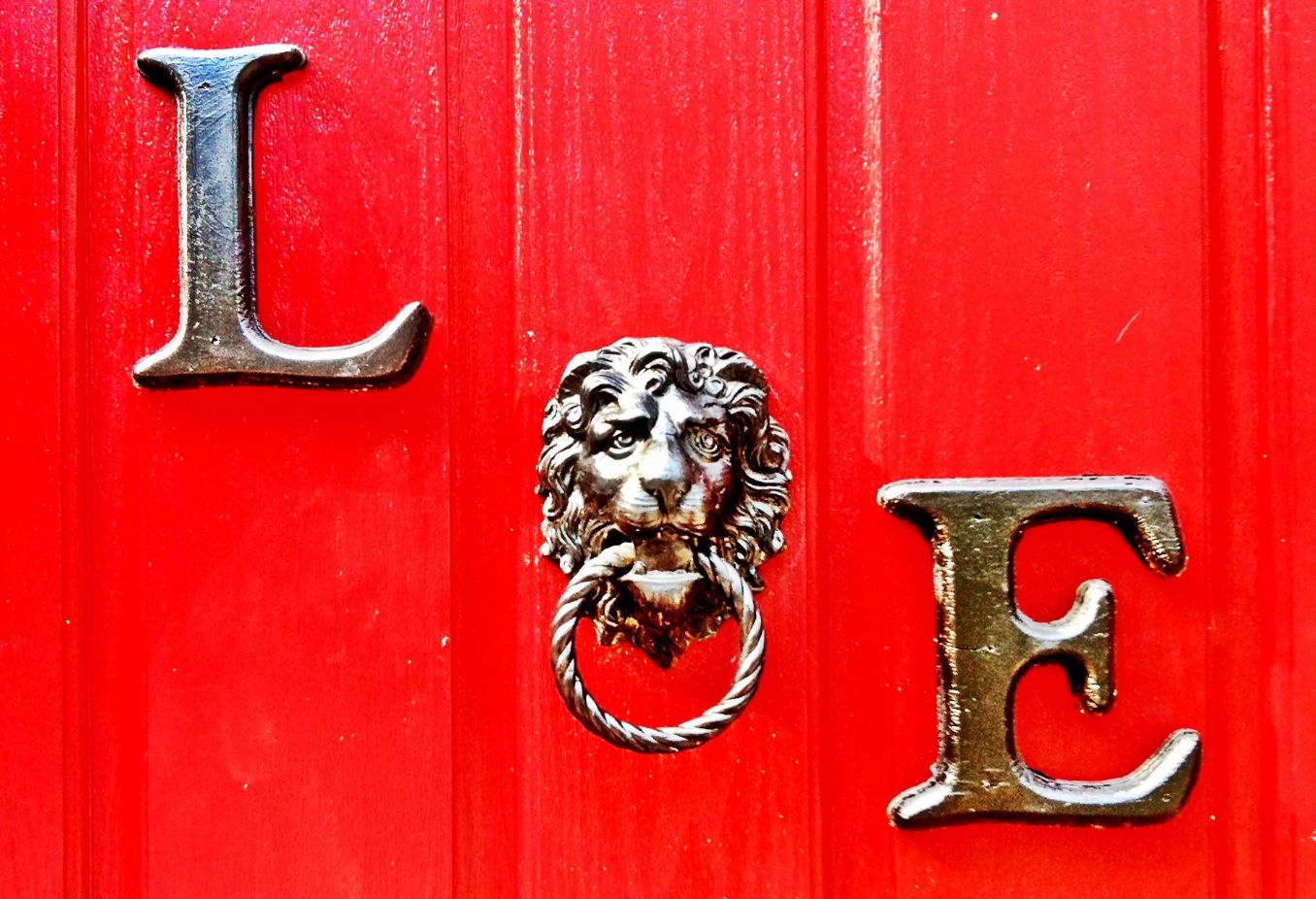 Brass L and E on the red door, with a lion knocker